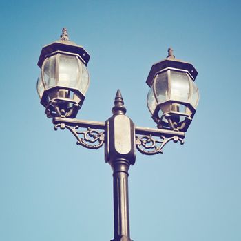 Old vintage street light against blue sky with retro filter effe