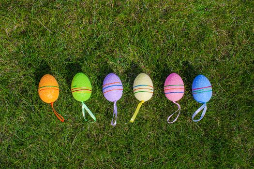 Multi-colored Easter eggs on green grass