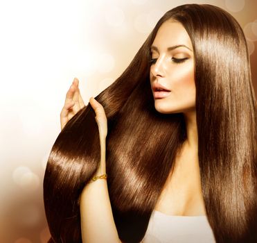 Beauty Woman touching her Long and Healthy Brown Hair 