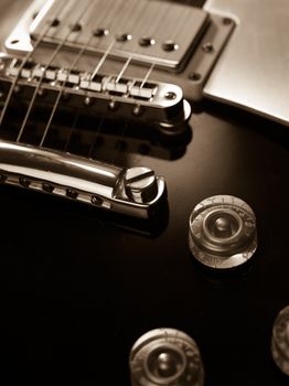 Macro abstract photo of the pickup, bridge and strings of an electric guitar. Shallow depth of field with focus across the middle.