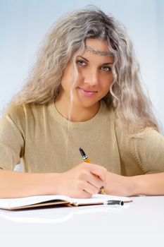 beautyful blonde writing with a ballpoint pen