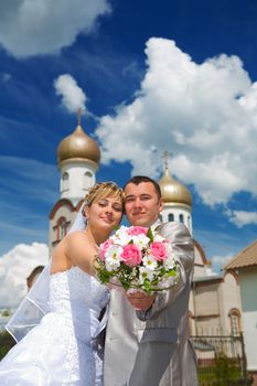 newlywed couple on a background of a church