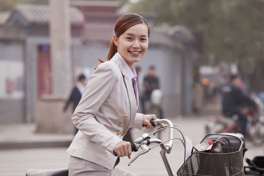 Young Business Woman standing with a Bicycle, Beijing, China