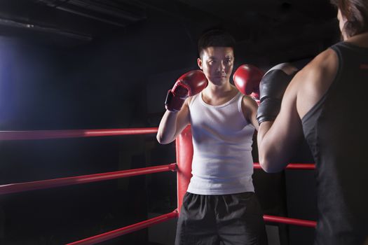 Over the shoulder view of two male boxers getting ready to box in the boxing ring in Beijing, China