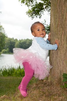 African little girl is holding the tree