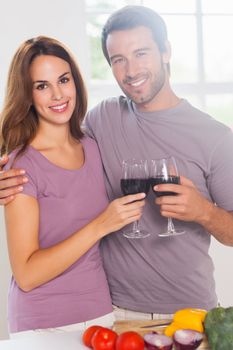 Lovers toasting with a glass of wine and looking camera