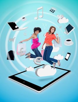 Two cute women jumping on a tablet pc 