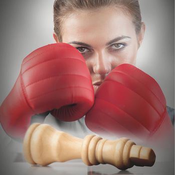 Powerful female boxer with knocked chess piece