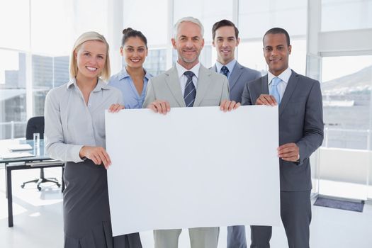 Business team holding large blank poster