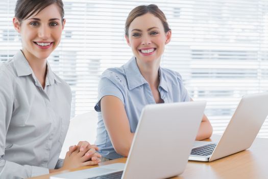 Happy businesswomen with laptops 