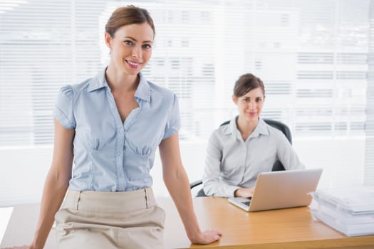 Businesswomen smiling at camera in their office