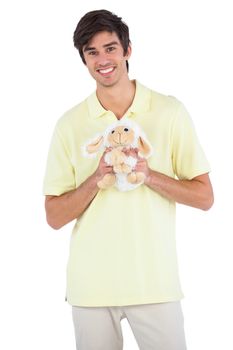Smiling man holding a sheep plush