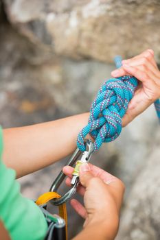 Female rock climber adjusting her harness