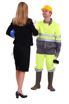 Businesswoman shaking the hand of a tradesman