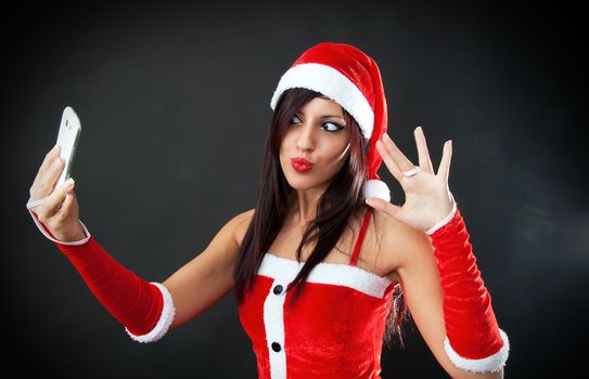 Beautiful sexy girl wearing santa claus clothes with smartphone