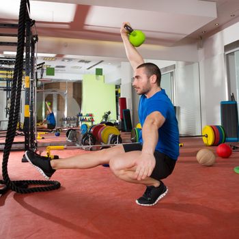 Crossfit fitness man balance Kettlebells with one leg