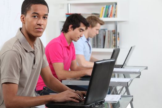 Young men working on their assignments in a computer lab