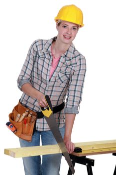 young female carpenter using saw