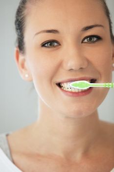 Pretty young woman cleaning her teeth