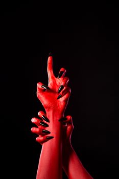 Scary red demonic hands with black nails, real body-art 