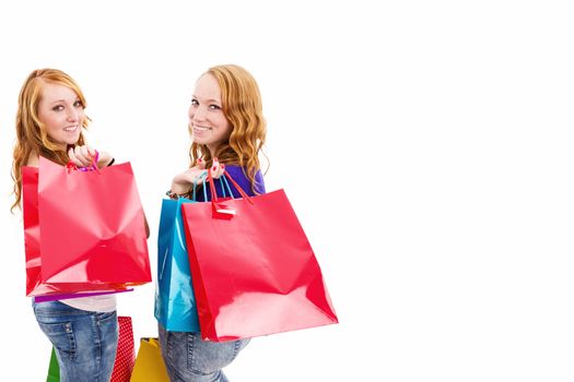 two happy women with shopping bags turning around