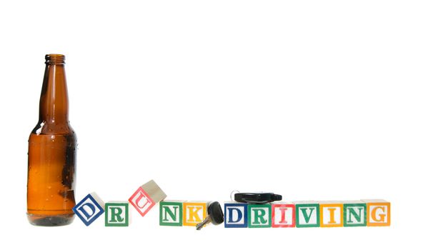 Letter blocks spelling drunk driving with keys and a beer bottle