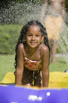 Girl (5-9) Sliding on water slide portrait.