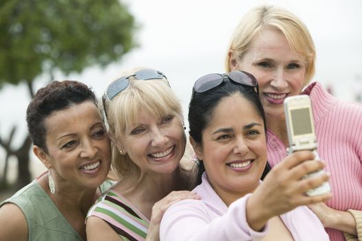 Group of middle-aged women photographing themselves with a mobile phone