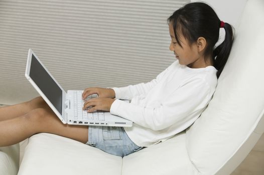 Young Girl in Chair Using Laptop side view
