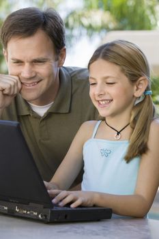 Father Watching Daughter Use Laptop