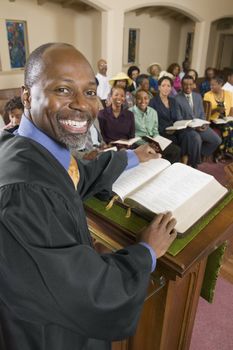 Preacher at altar with Bible preaching to Congregation portrait