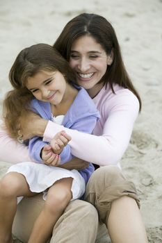 Mother embracing daughter on beach