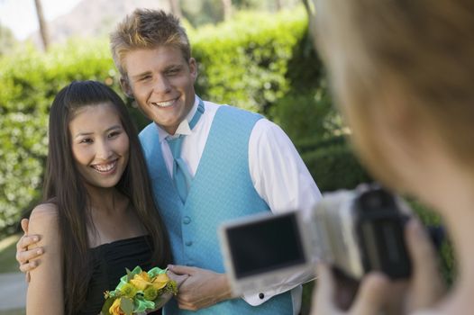 Well-dressed teenager couple posing for video camera outside school dance
