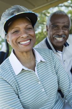 Closeup portrait of happy senior couple in golf course smiling