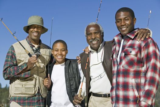 Portrait of a happy multi generation African family holding fishing rods