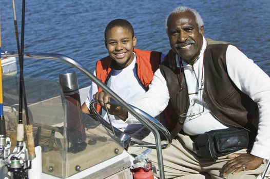 Portrait of an African American man sitting with grandson in a boat