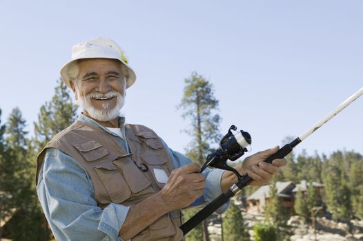Portrait of happy Hispanic senior man enjoys a day of fishing