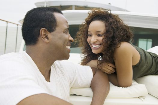 Happy African American couple looking at each other while travelling on yacht