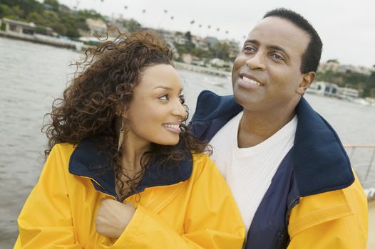 Happy African American couple in yellow jacket on the yacht