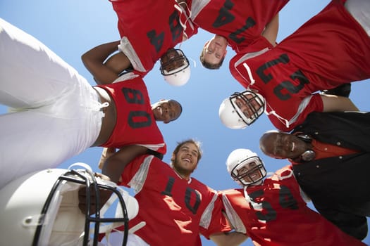 Football Players and Coach in Huddle view from below (view from below)