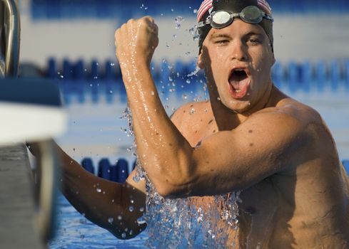 Portrait of ecstatic male swimmer cheering with clenched fist