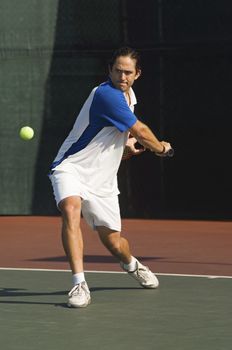 Full length of male tennis player about to hit a ball