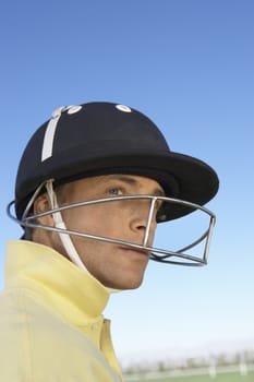 Polo player wearing helmet against clear sky