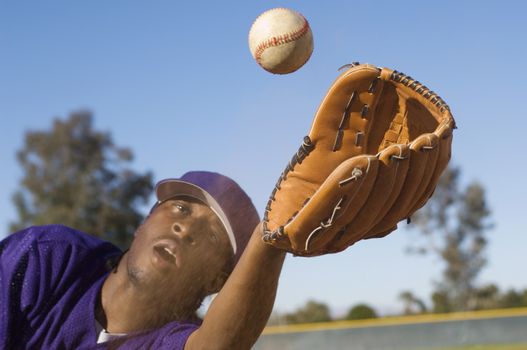 An African American man catching baseball