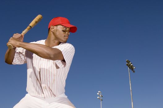 Confident African American baseball batter waiting to strike the ball