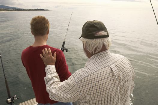 Rear view of man with grandfather fishing on yacht