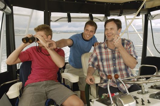 Happy friends on yacht looking at something
