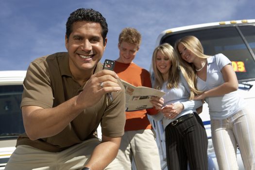 Portrait of mature man with keys to RV with customers