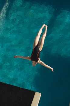 High angle view of a female swimmer in midair diving