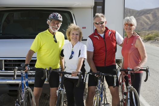 Two Senior couples with bikes on road